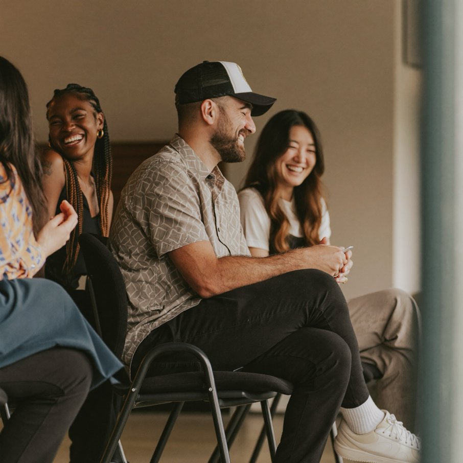 A diverse team of church volunteers laughing together during a planning meeting